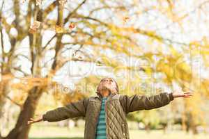 leaves drop onto a little boy with outstretched arms