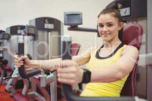 Fit woman using weights machine