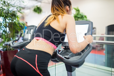 Woman on an exercise bike looking at the tv screen