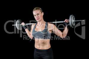 Muscular woman lifting heavy barbell