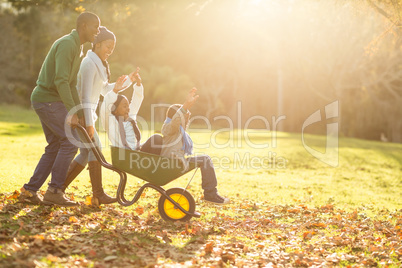 Young parents holding their children in a wheelbarrow