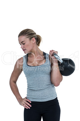 Serious muscular woman lifting kettlebell