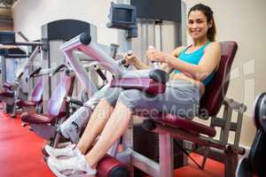 Smiling woman sitting in the weights machine