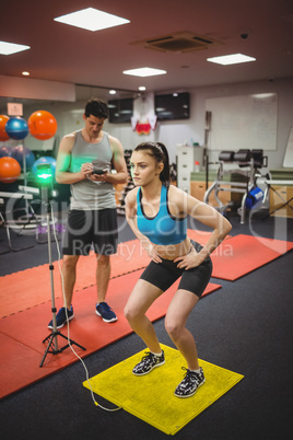 Fit woman measuring her jump with trainer
