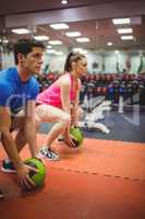 Fit couple working out in weights room