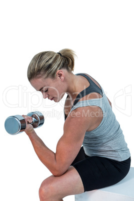 Muscular woman working out with dumbbells