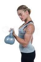 Serious muscular woman lifting kettlebell