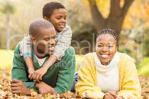 Portrait of a young family lying in leaves