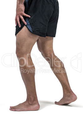 Muscular man flexing leg for camera