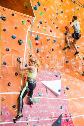 Fit couple rock climbing indoors