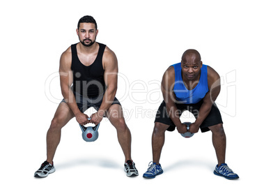 Strong friends lifting kettlebells together