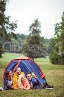 Happy friends lying in their tent taking selfie