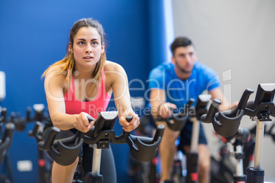 Man and woman using exercise bikes