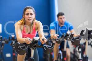 Man and woman using exercise bikes