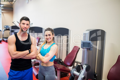 Woman and her trainer by the weights machines