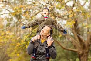 Young dad lifting his little son in park