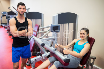 Smiling woman sitting in the weights machine