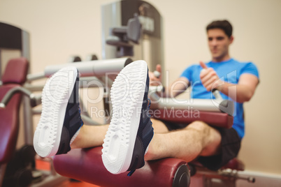 Fit man using weights machine for legs