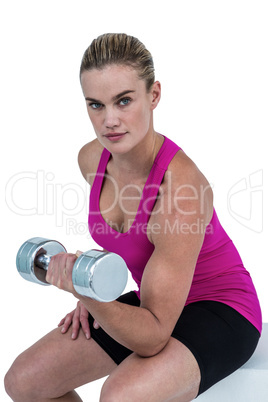 Muscular woman exercising with dumbbells