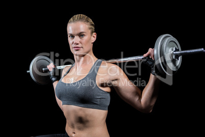 Muscular woman lifting heavy barbell