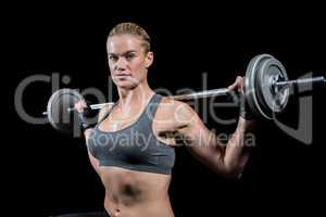 Muscular woman lifting heavy barbell