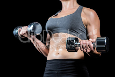 Muscular woman lifting heavy dumbbells