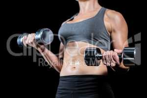 Muscular woman lifting heavy dumbbells