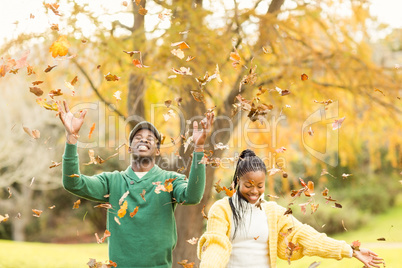 Portrait of a young couple throwing leaves around