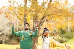 Portrait of a young couple throwing leaves around