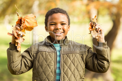 Portrait of a little boy holding leaves