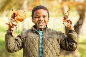 Portrait of a little boy holding leaves