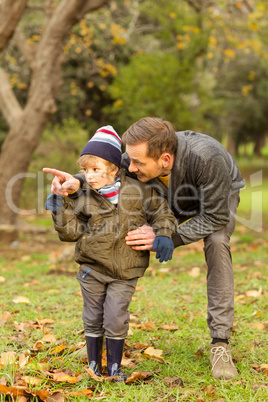 Young father showing something to his cute son