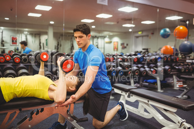 Woman lifting dumbbells with her trainer