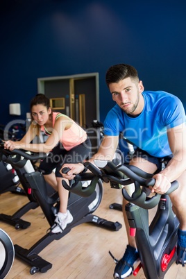 Man and woman using cycling exercise bikes