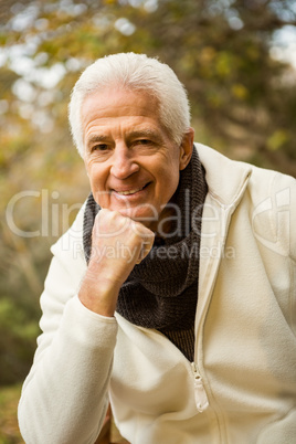 Happy senior man posing with hand on chin