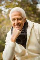Happy senior man posing with hand on chin