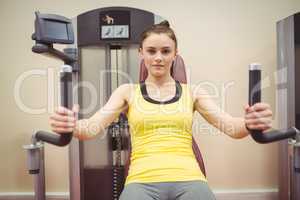 Fit woman using weights machine