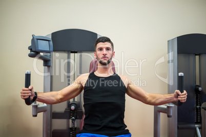 Focused man working out on the weights machine