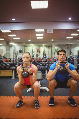 Fit couple working out in weights room