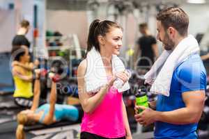 Fit couple chatting in weights room