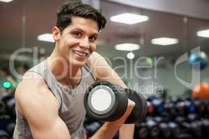 Smiling man lifting dumbbell weight