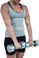 Muscular woman working out with dumbbells