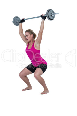 Sporty female bodybuilder lifting barebell