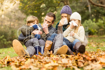 Young family blowing their nose