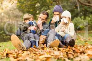 Young family blowing their nose