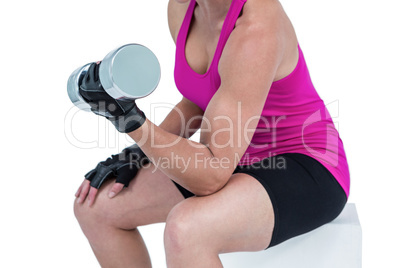 Muscular woman exercising with dumbbells