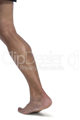 Muscular man flexing leg for camera