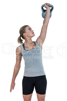 Serious muscular woman lifting kettlebell