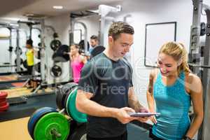 Client and trainer looking at tablet pc