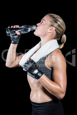 Muscular woman drinking water